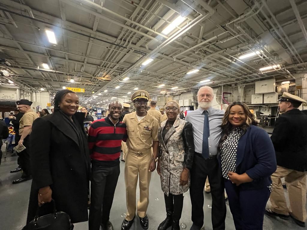 A group of people are posing for a picture in a warehouse.
