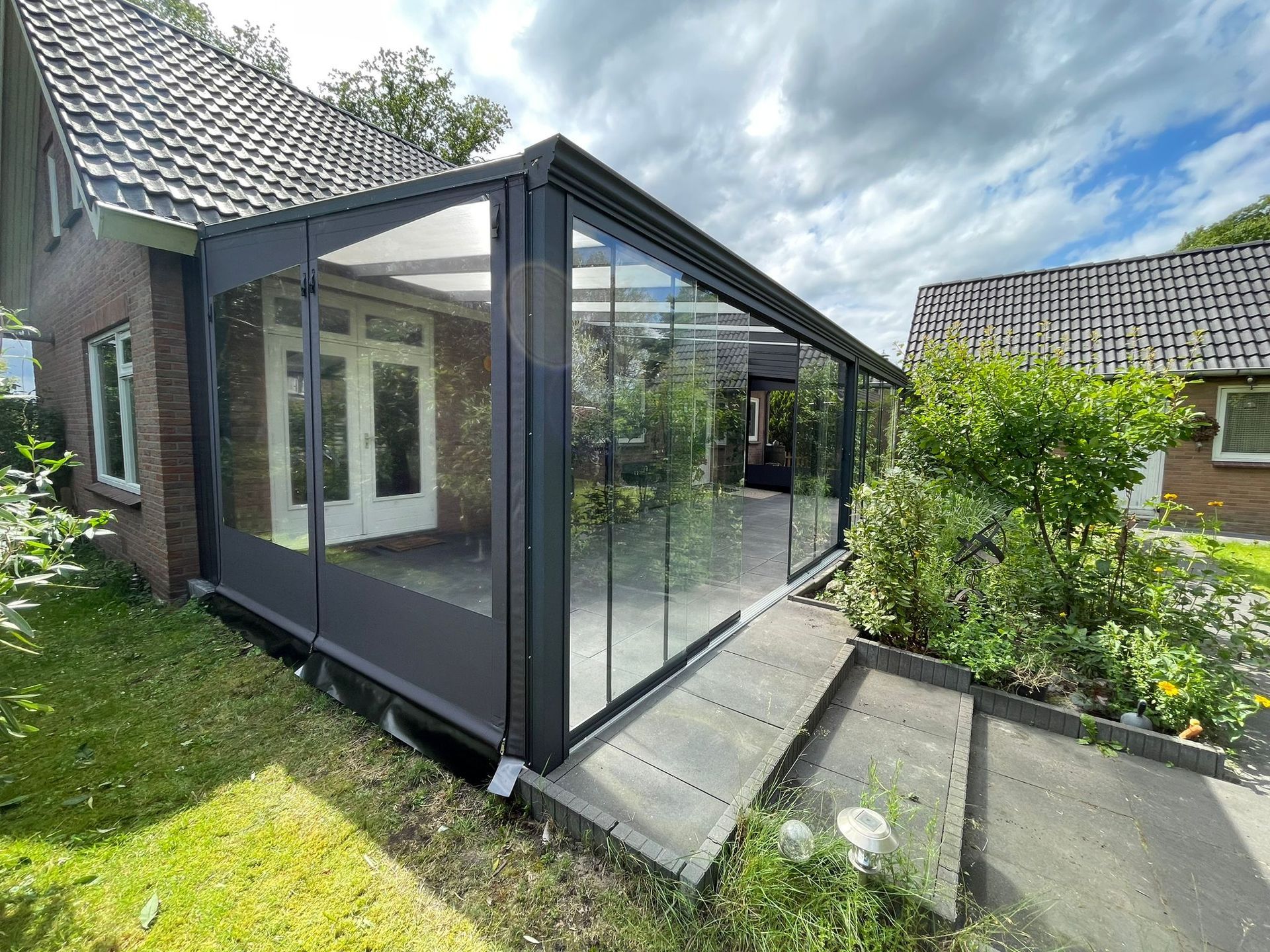 Een huis met een glazen schuifdeur en een looppad ernaartoe.