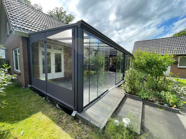 Een huis met een glazen schuifdeur en een looppad ernaartoe.
