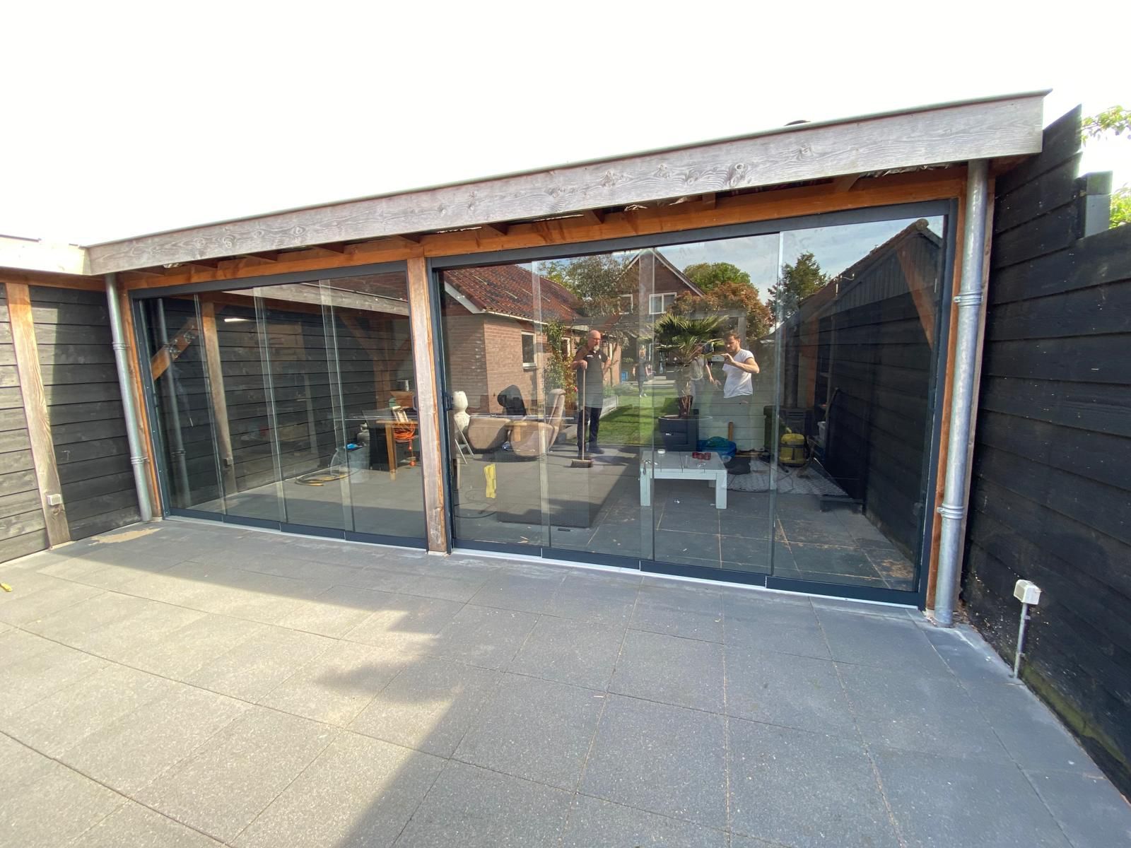 Een huis met veel ramen en een terras ervoor.