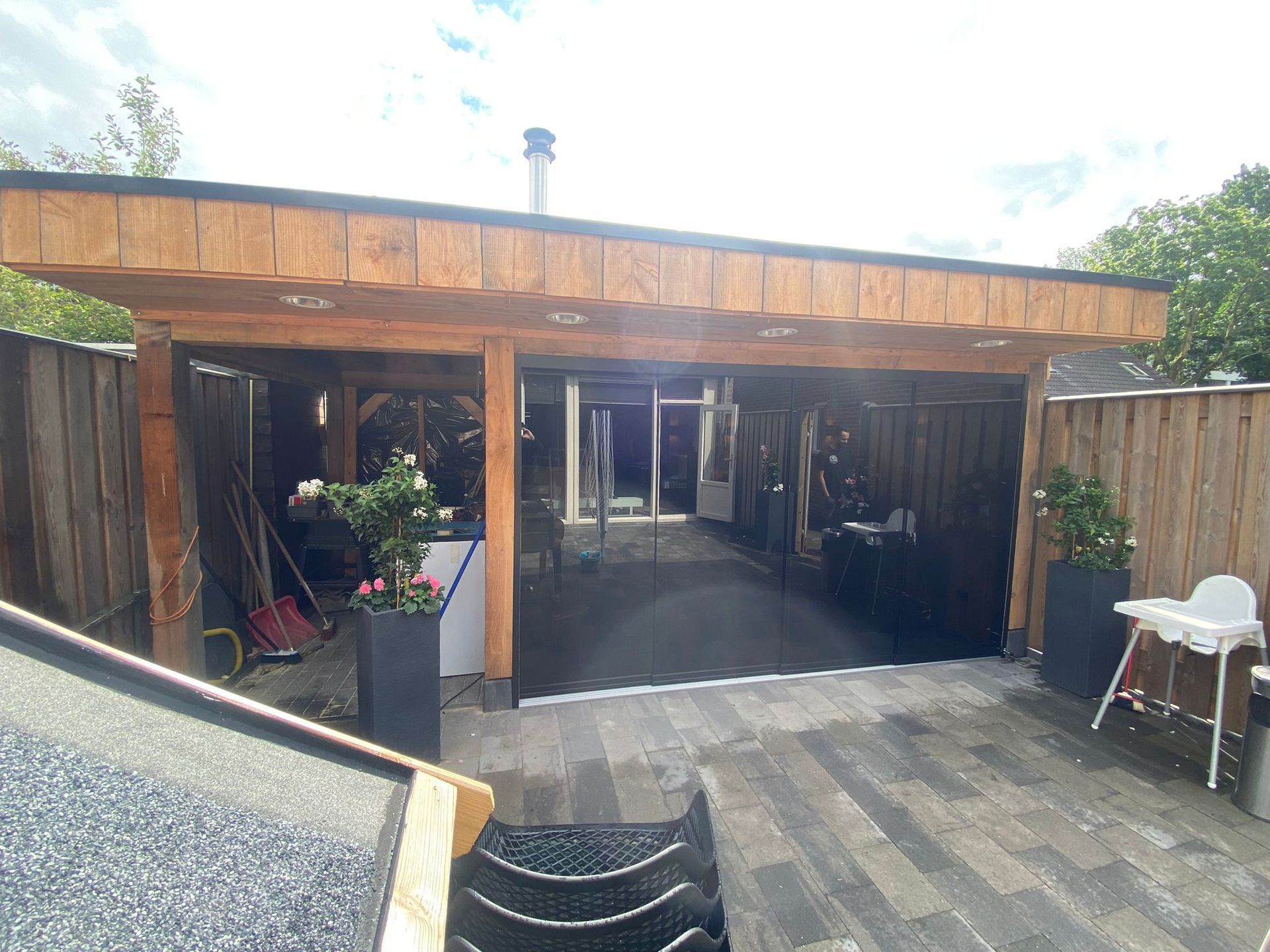 Een houten gebouw met een glazen schuifdeur in de achtertuin.