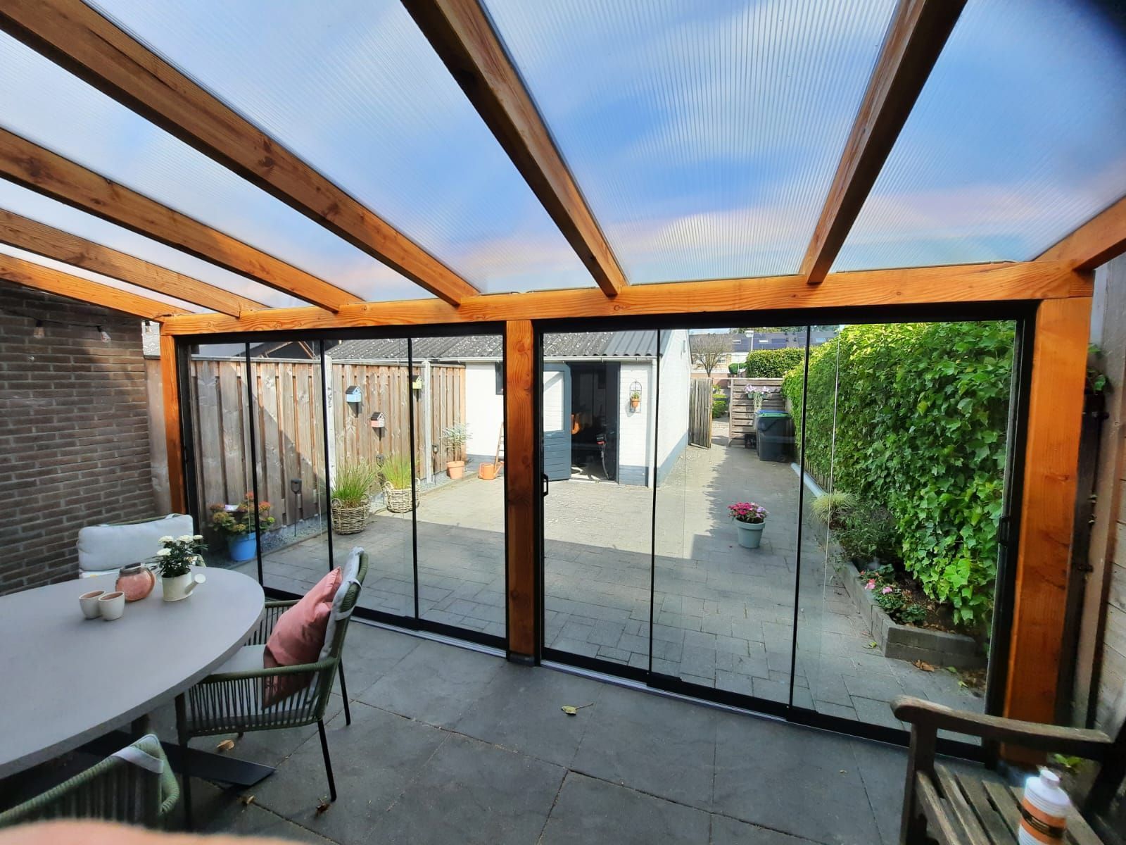 Een terras met een tafel en stoelen en een glazen schuifdeur