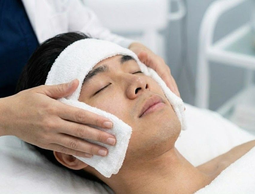 applying a cool, damp towel to a clients face to neutralise the continuing effects of the acid on the face.