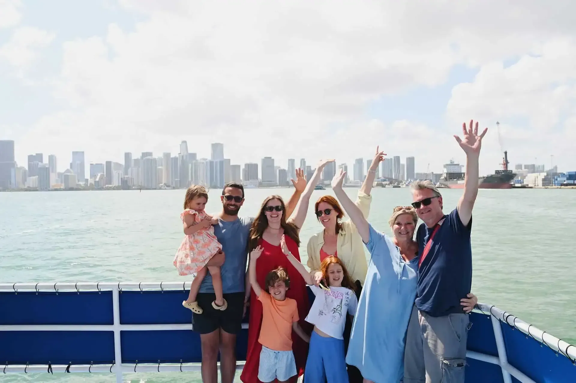 Family enjoying a sightseeing cruise on Biscayne Bay with the Miami skyline behind them.