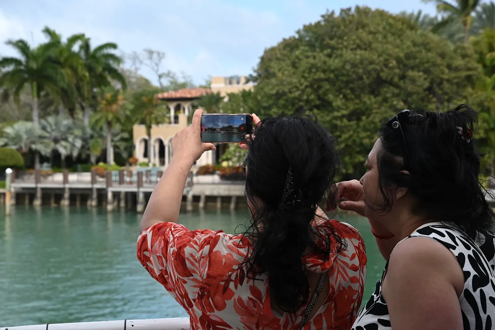 Guests taking photos of celebrity homes on a Miami boat tour