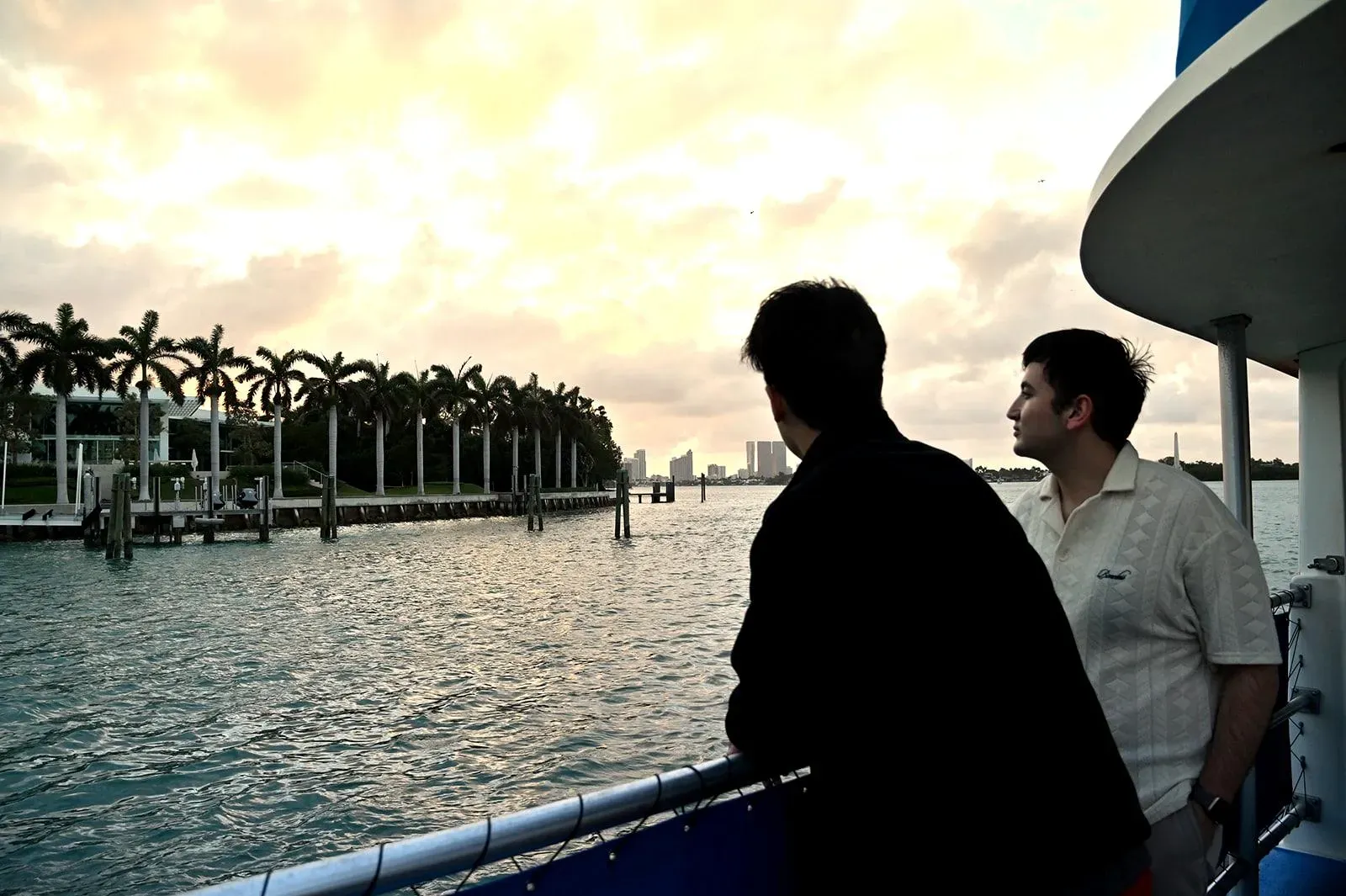 Guests enjoying a Miami boat tour of celebrity homes at sunset with mansion views on Biscayne Bay