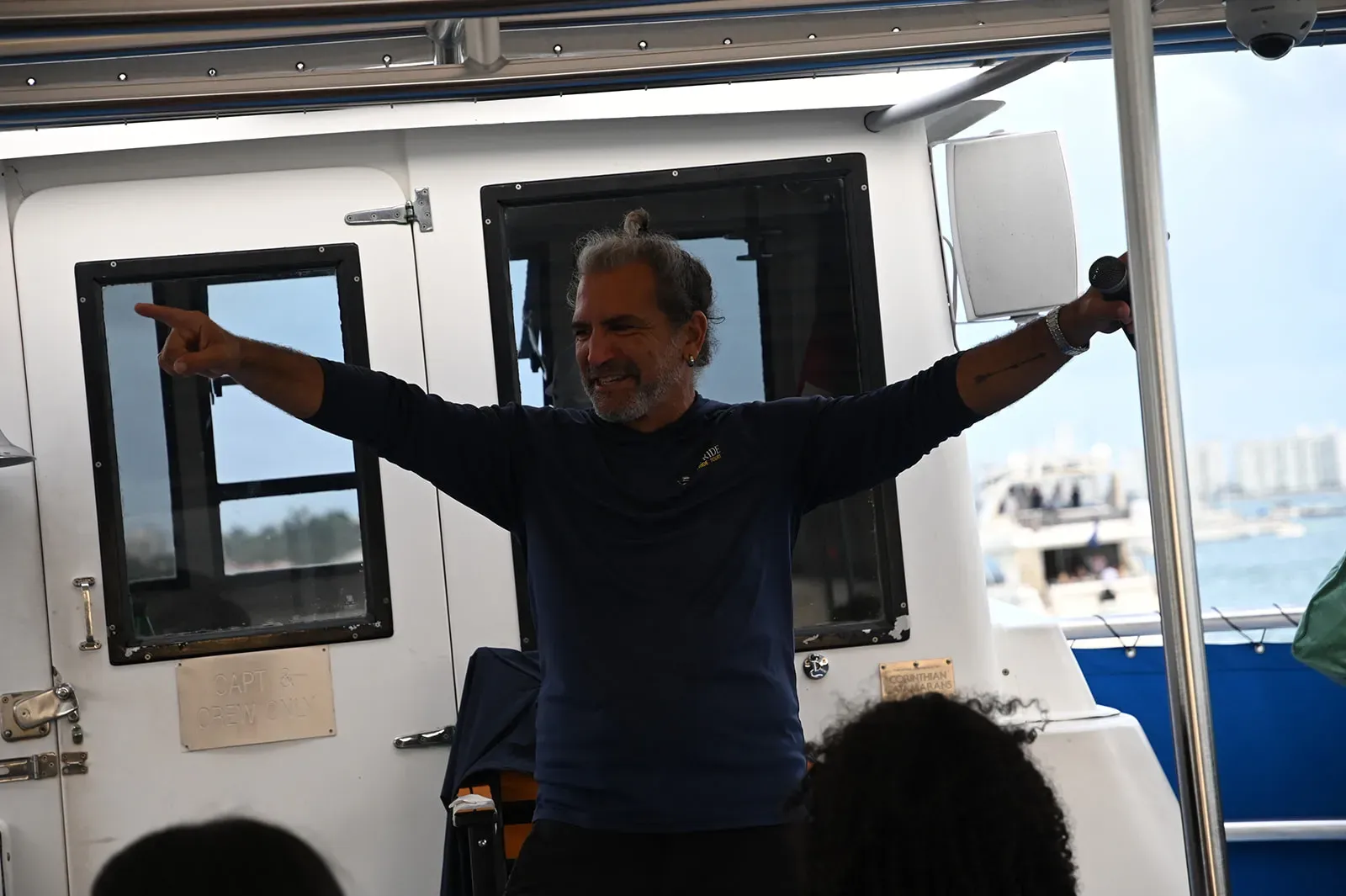 Live tour guide interacting with guests during a Miami boat tour onboard experience