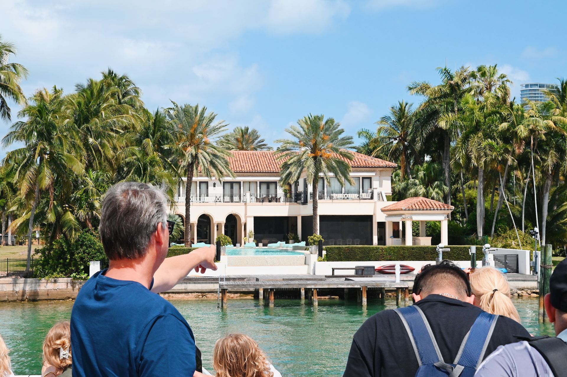 Passengers pointing at the Mansions on Star Island from the Boat tour in Miami