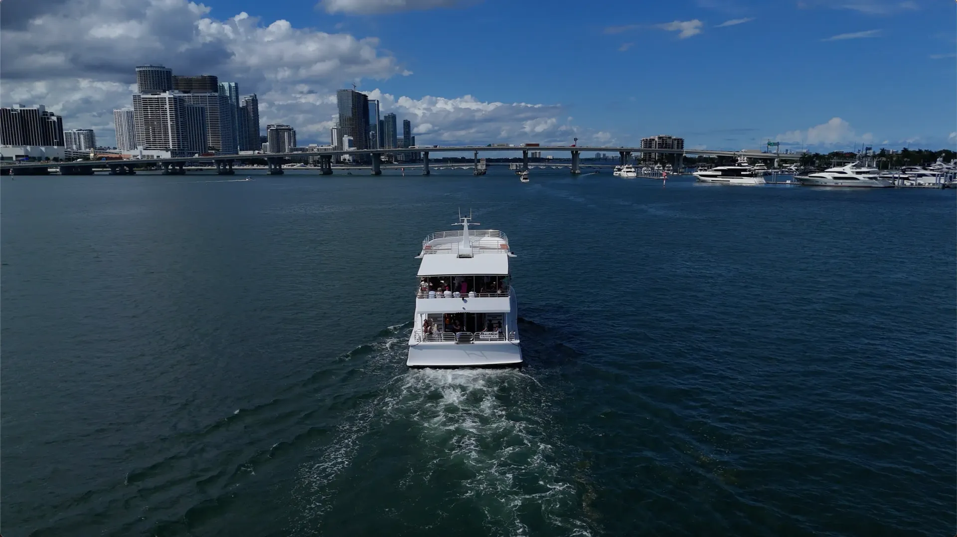 Miami Boat Tour cruising through Biscayne Bay with the Miami skyline in the background.