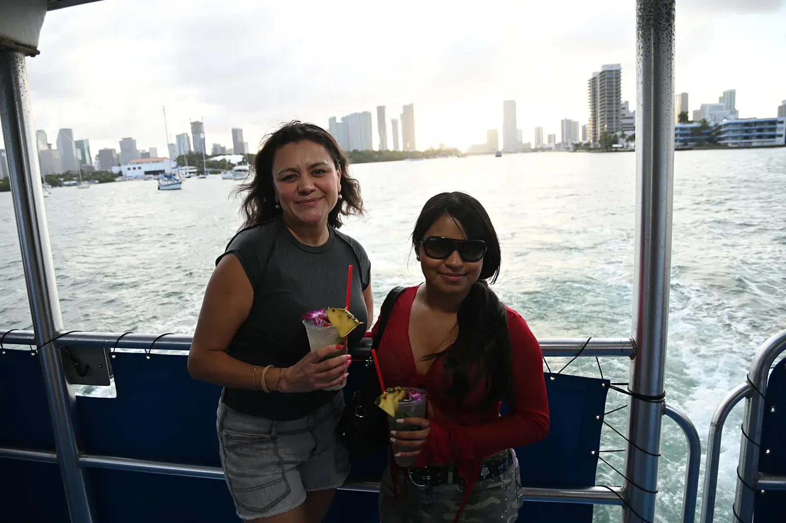 guests enjoying drinks on Miami Boat Tours during sunset with skyline views