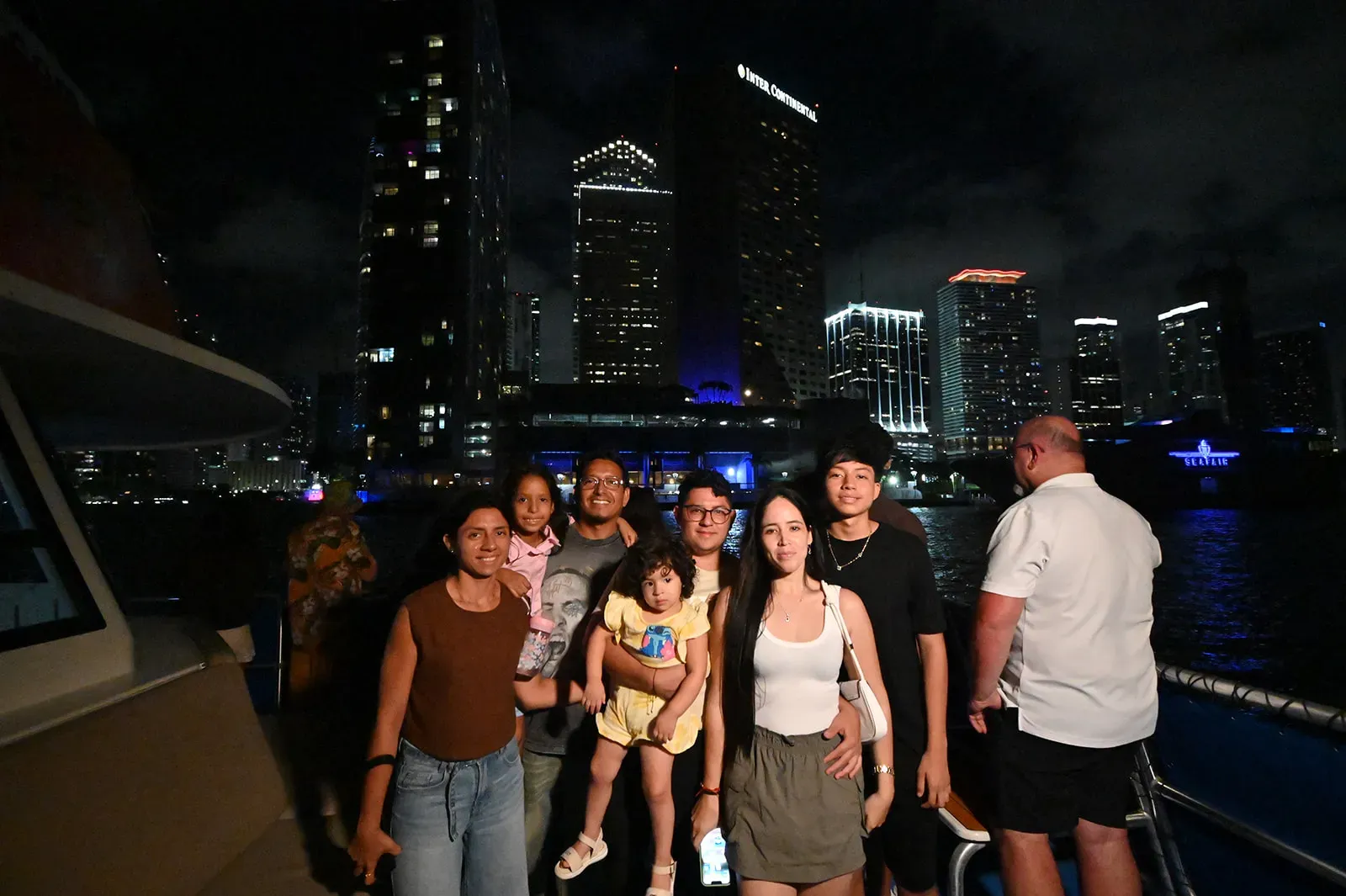 family enjoying Miami Boat Tours at night with skyline views on Biscayne Bay