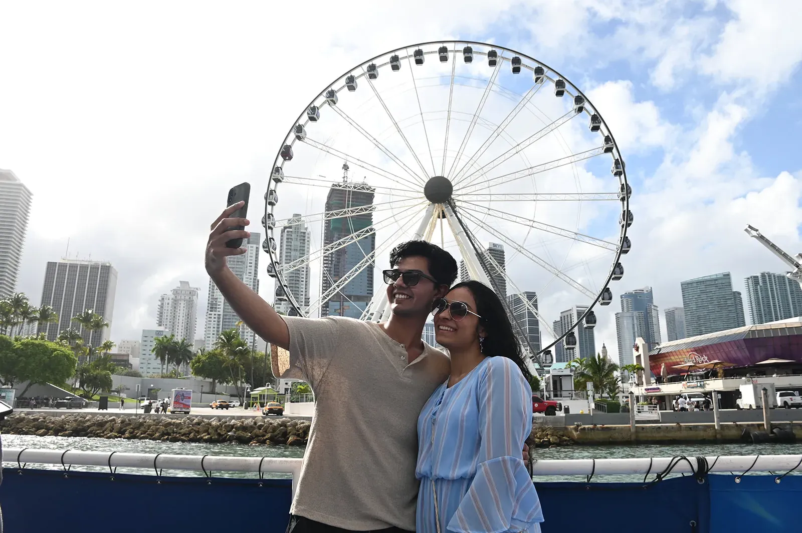 couple taking a selfie on Miami Boat Tours with the Miami Skyviews wheel and downtown skyline in the background