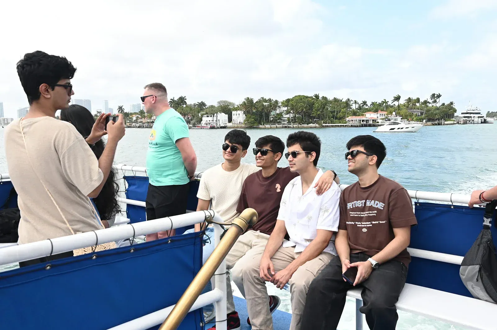 people enjoying a miami sightseeing boat cruise on biscayne bay with views of waterfront homes and yachts