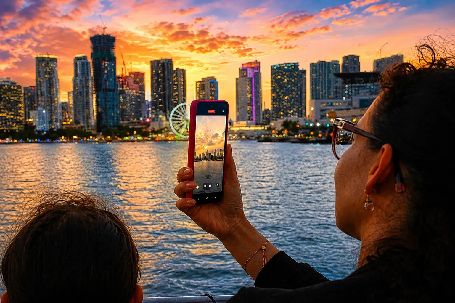Visitor photographing the Miami skyline during a winter sightseeing cruise on Biscayne Bay