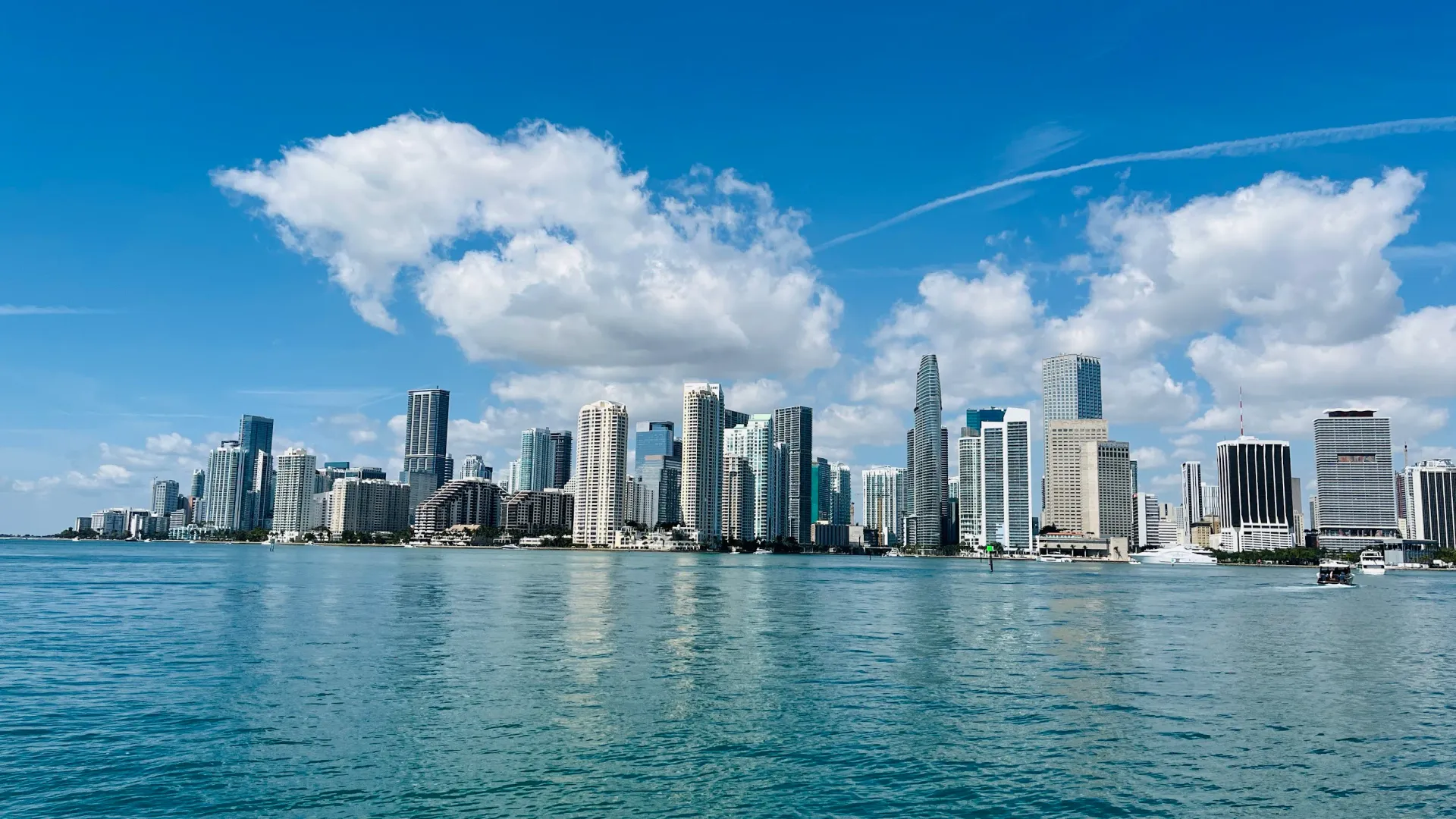 Miami skyline viewed from Biscayne Bay on a clear sunny day, featuring the Downtown Miami and Brickell skyline.