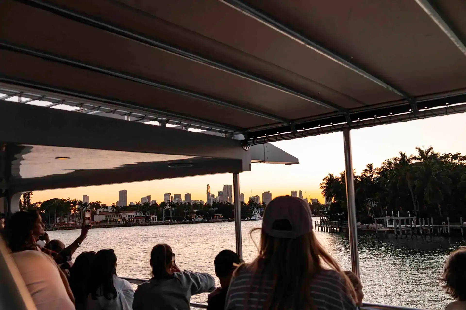 Passengers enjoying sunset skyline views from a Miami boat tour near Star Island.