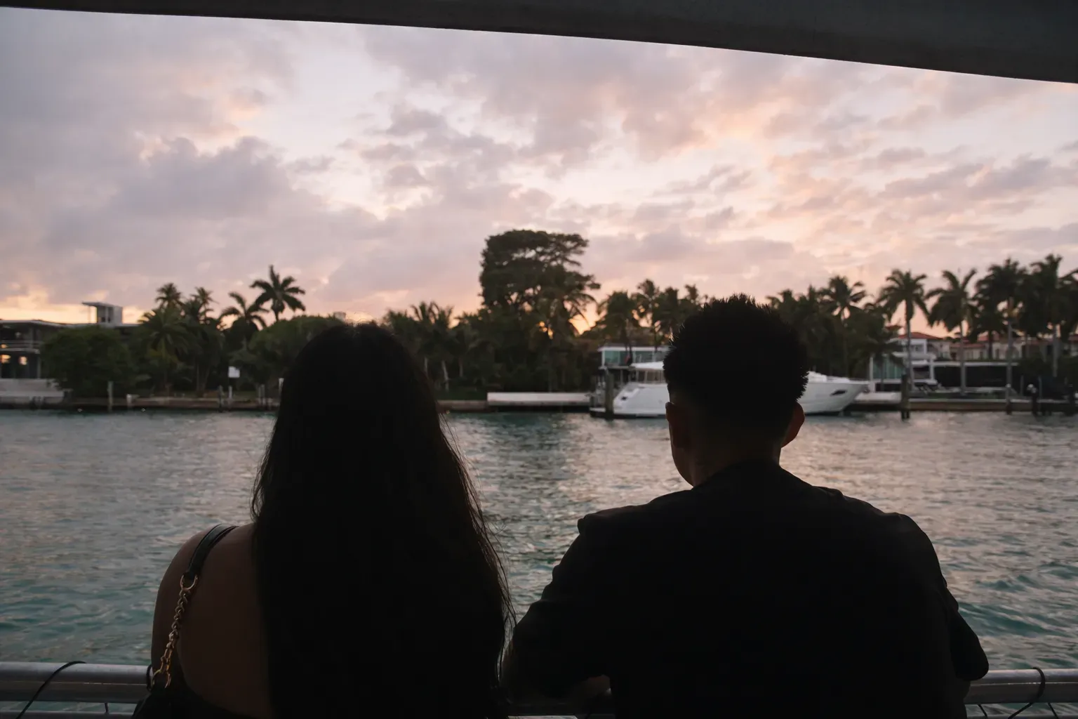 Couple enjoying a Miami sunset cruise passing celebrity mansions and Star Island on Biscayne Bay