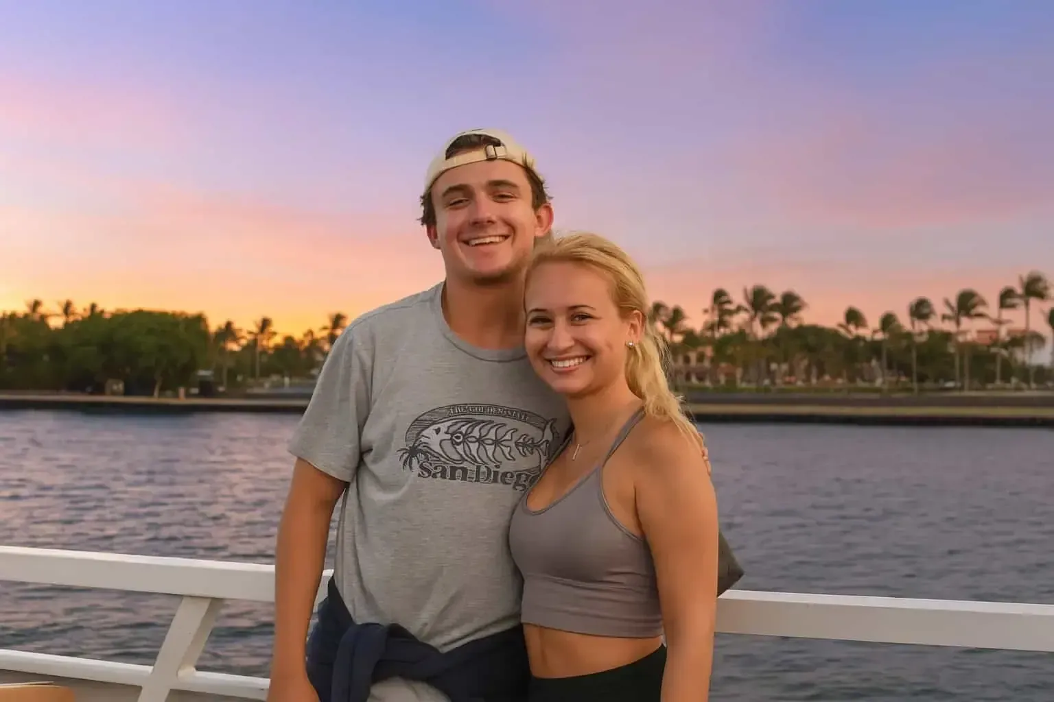 Couple posing for a photo during a sunset sightseeing cruise in Miami with the skyline in the background.