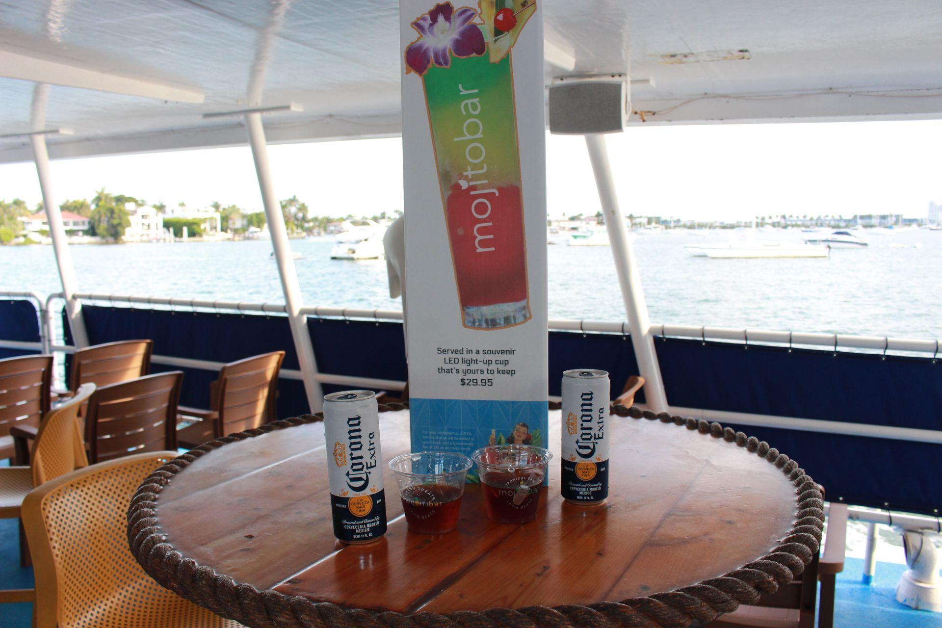 tables with the Mojito Bar onboard with the Mojito Bar sign and two beers