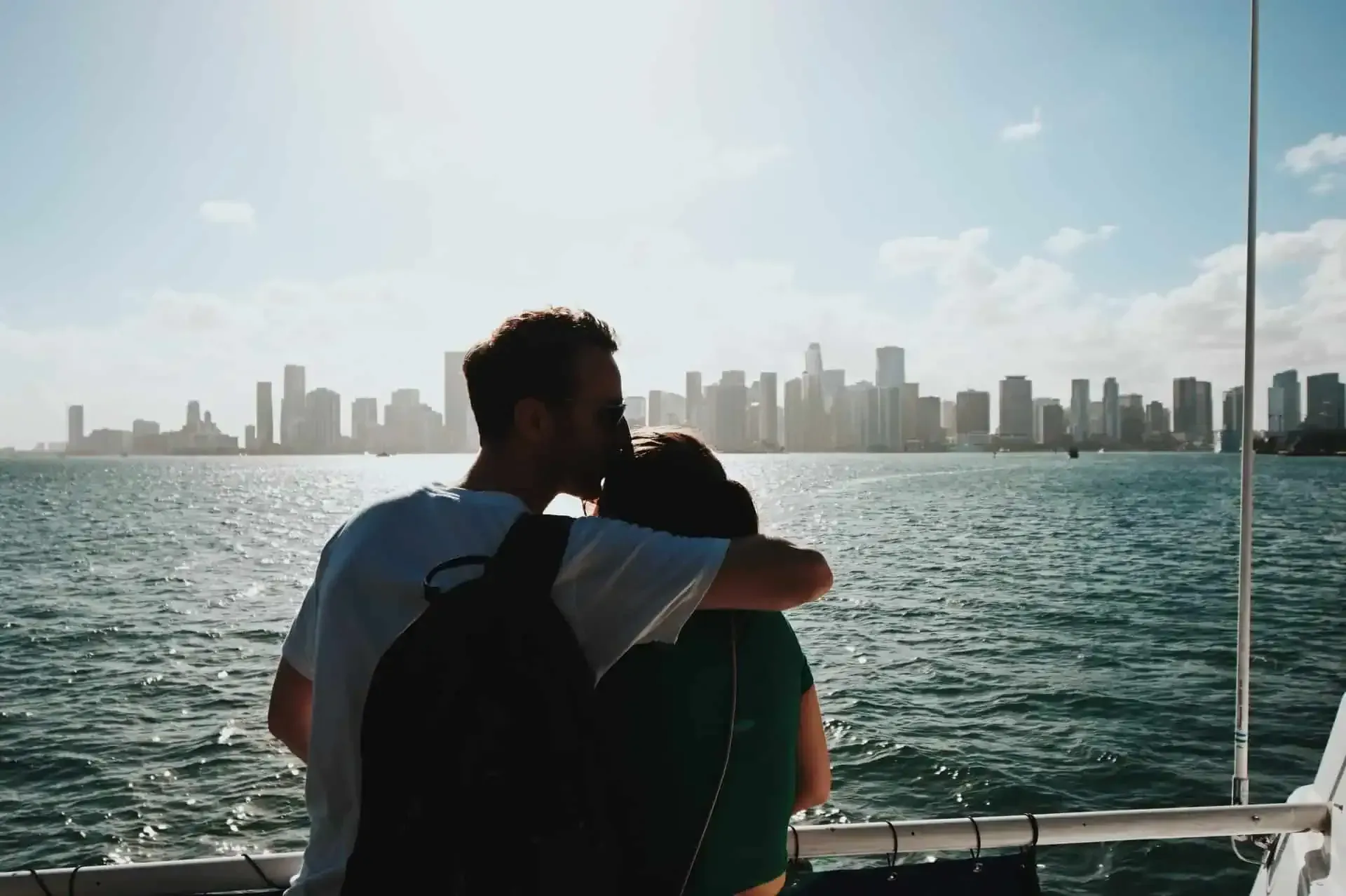 Couple enjoying a romantic sunset cruise on Biscayne Bay with the Miami skyline in the background.