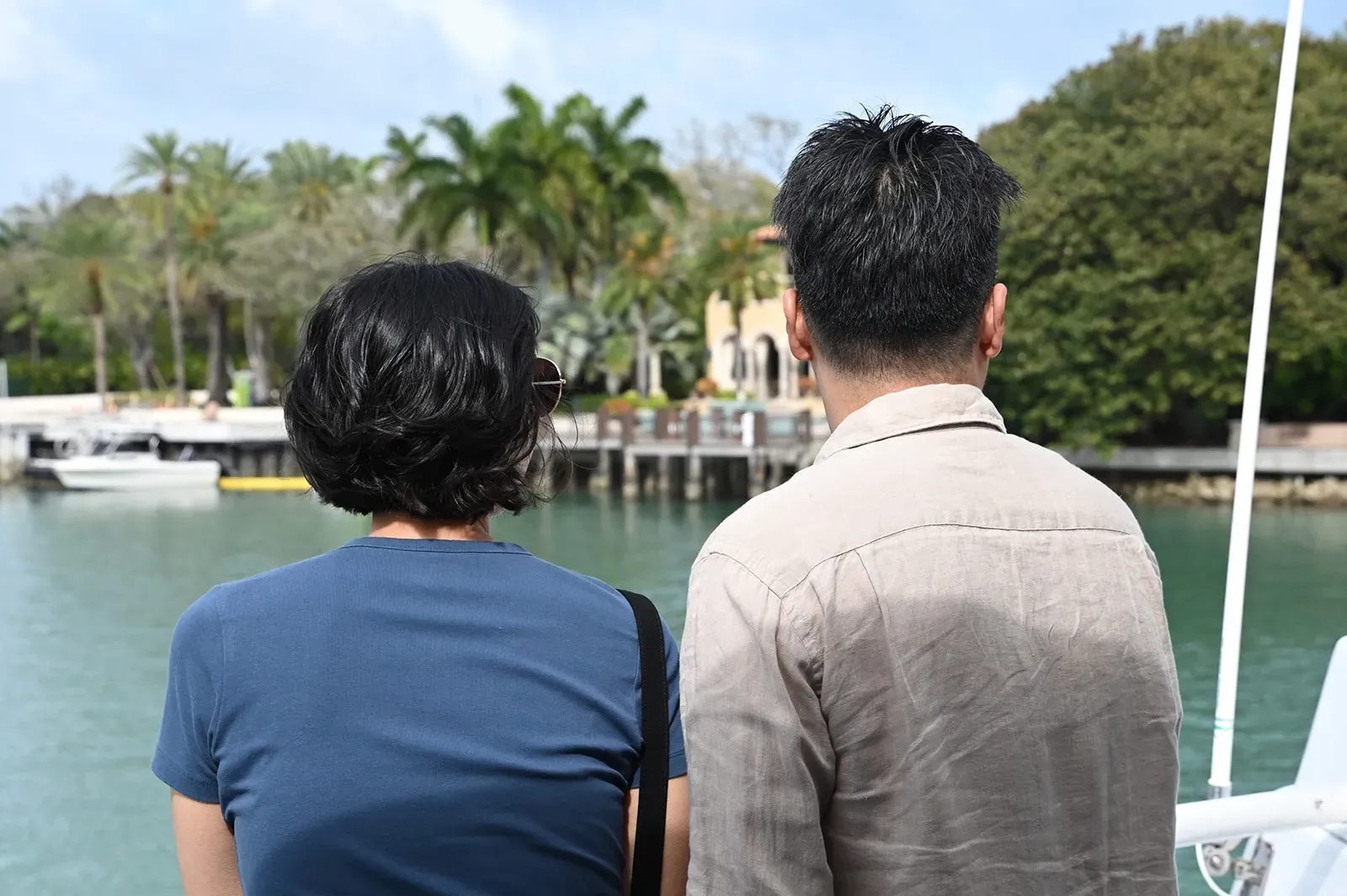 Couple viewing a waterfront mansion during a Star Island boat tour Miami