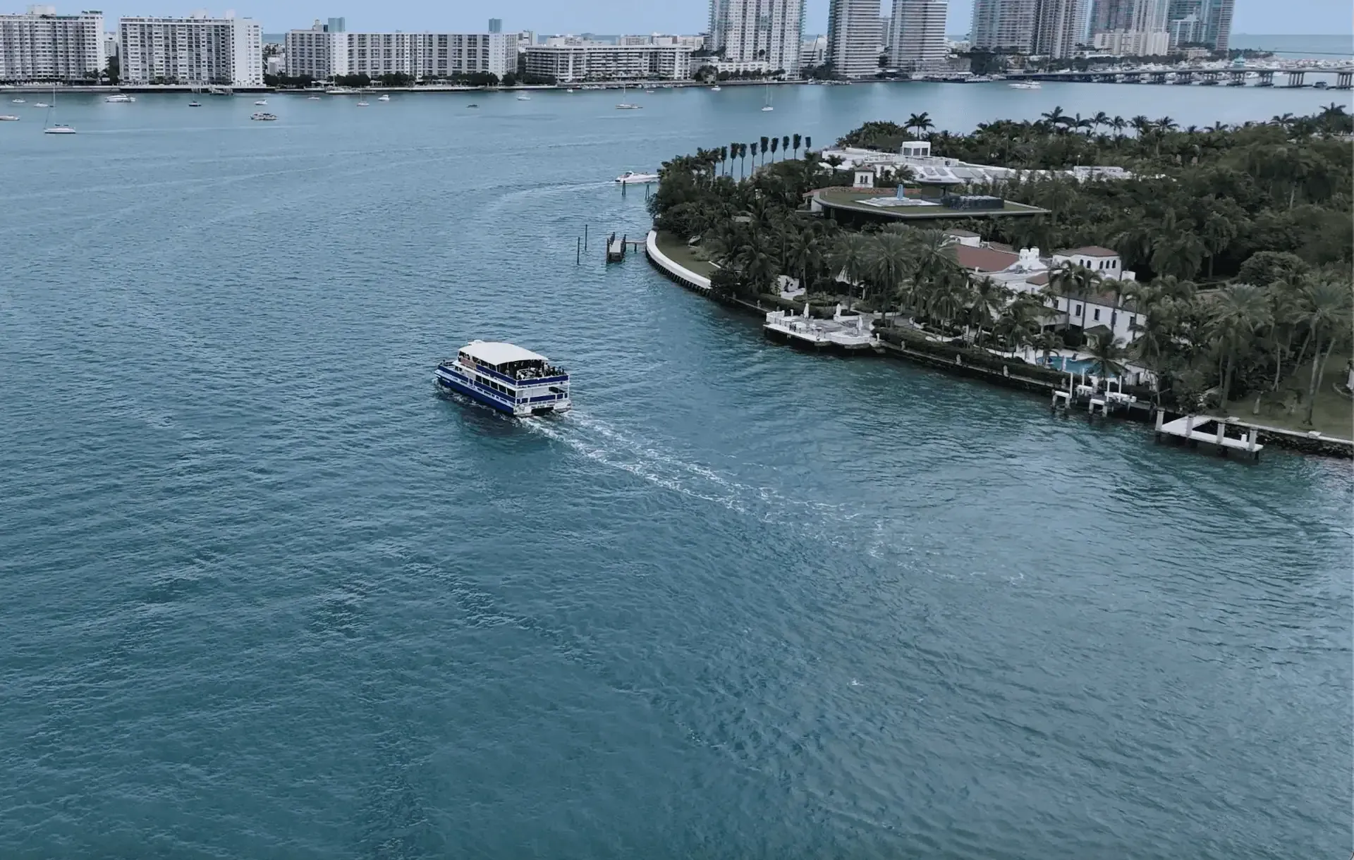 Aerial view of a sightseeing boat passing Star Island on Biscayne Bay in Miami.