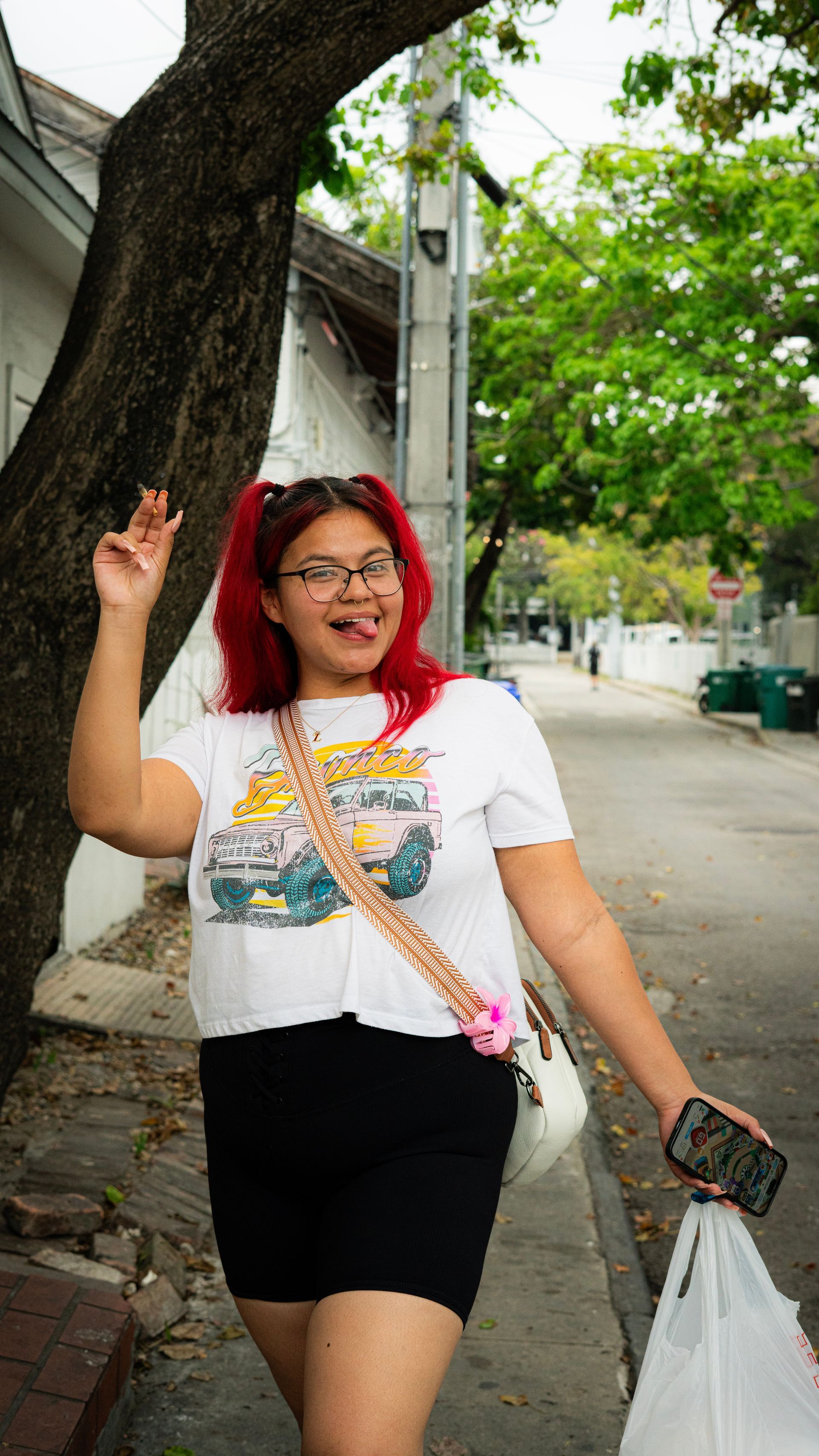 Tourist smiling and walking with shopping bags on a street in Key West