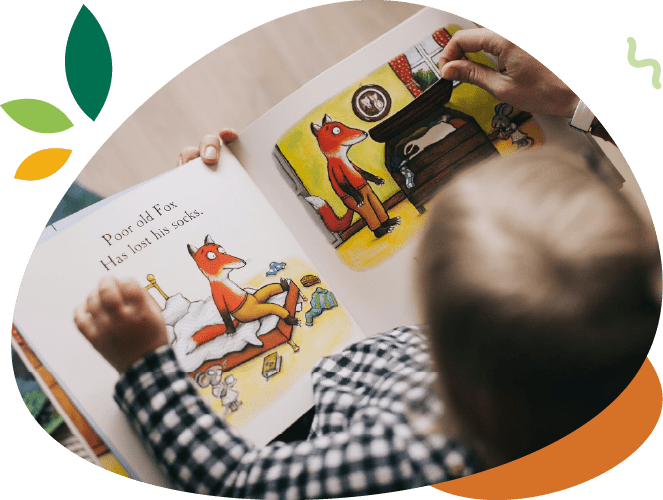 A child is reading a book with a fox on it