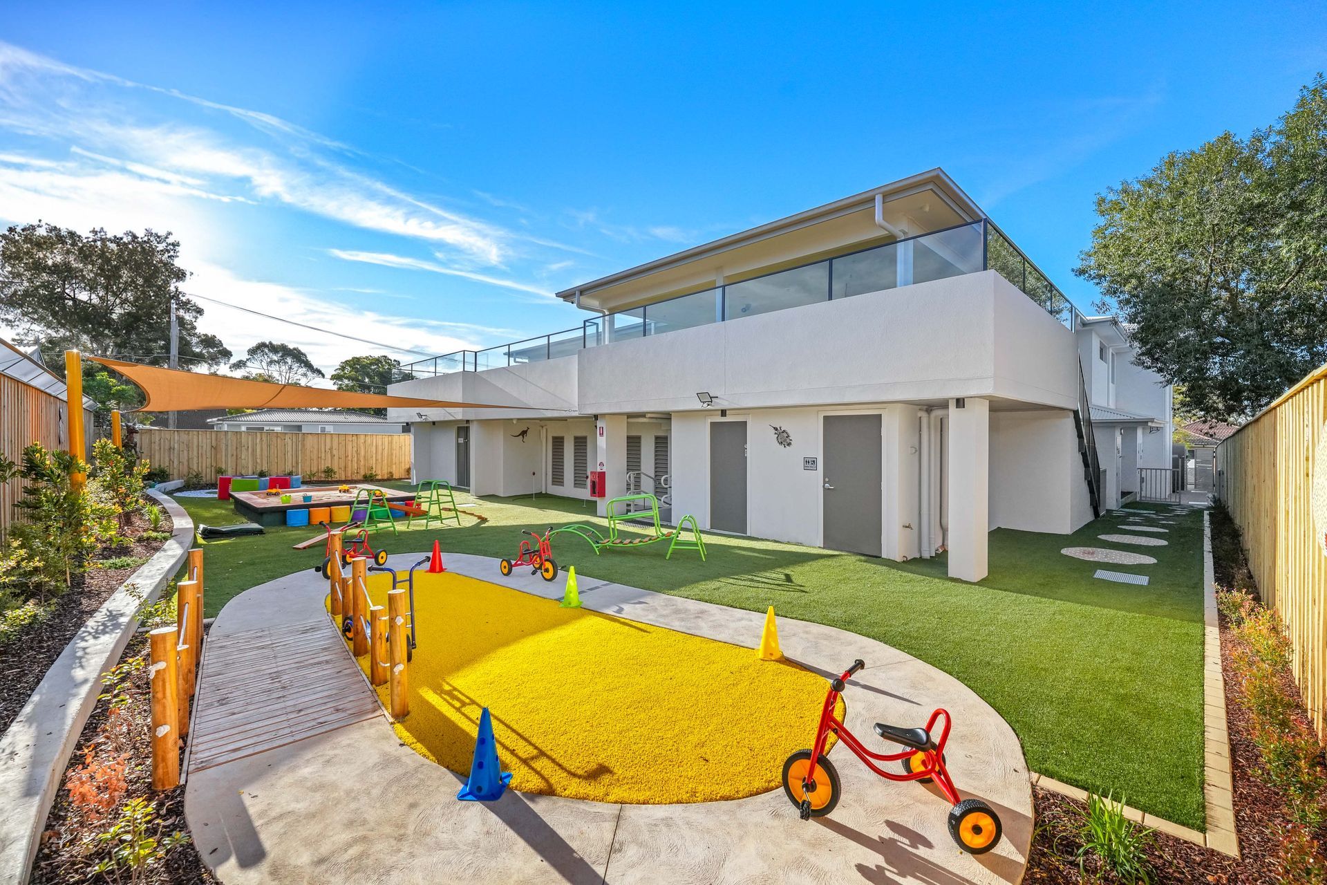 Childcare center with a two-story building, outdoor play area with artificial turf,