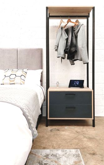 750 cm open bedrobe, bedside cabinet and wardrobe combination with a hanging rail and 2 drawers,  shown directly next to a bed. In Egger Natural Halifax Oak & Soft Black