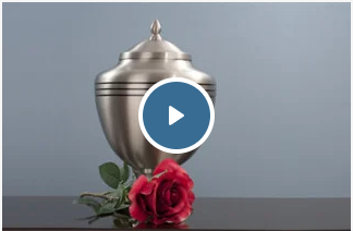 a silver urn with a red rose next to it on a table .