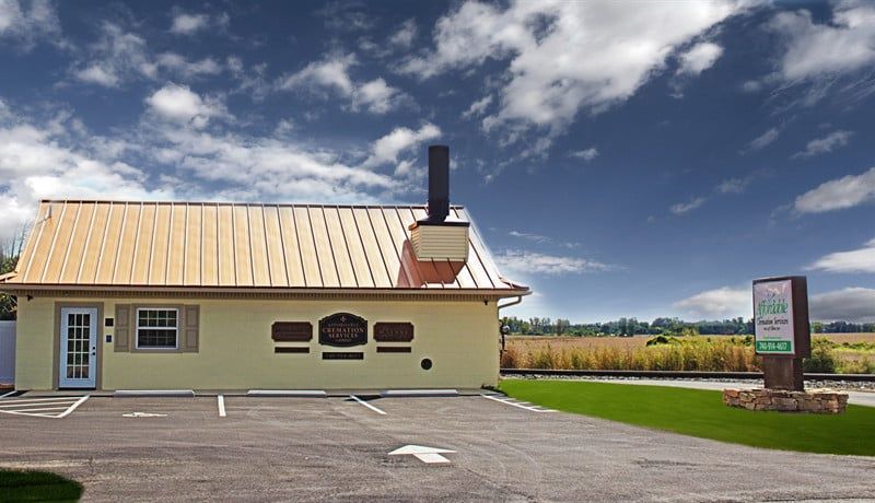 a small yellow building with a chimney on the roof is sitting in a parking lot .