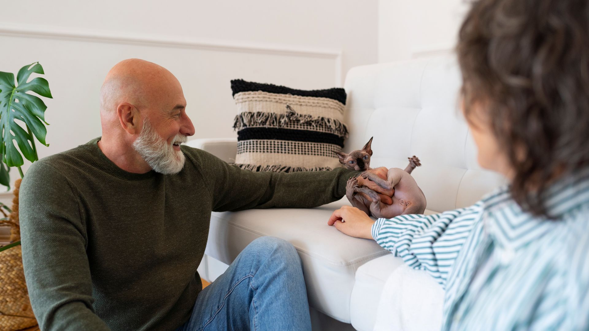 A man and a woman are sitting on a couch talking to each other.
