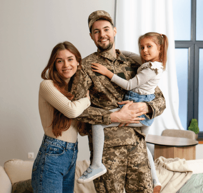 A family is sitting on a couch holding a drawing of their family.