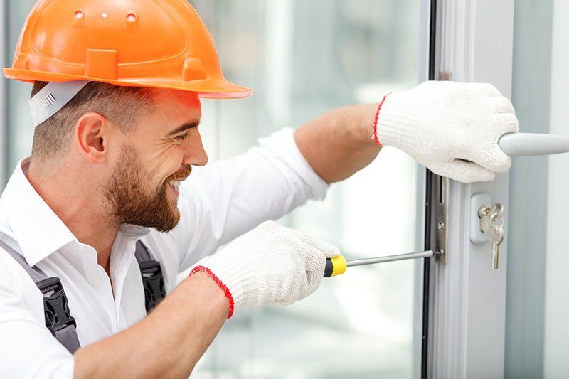 A Man Fixing a Door Lock — Coast & Hinterland Mobile Locksmiths In Noosaville, QLD