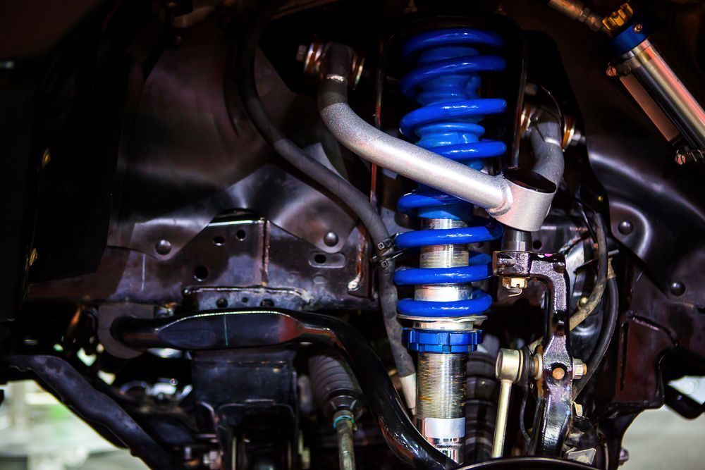 Blue Coilover Shock Absorber in a Vehicle's Undercarriage — CE Automotive Service Centre in Garbutt, QLD
