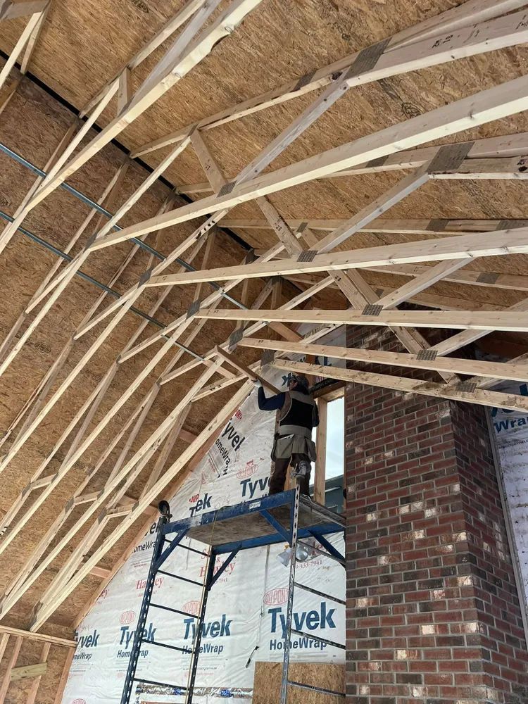 A man is standing on a scaffolding in a building under construction.