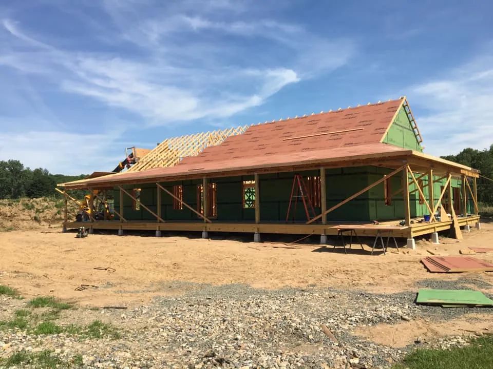 A large house is being built in a dirt field.
