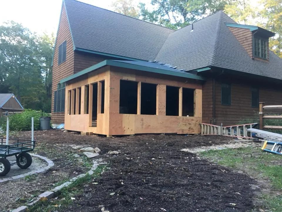 A house with a porch being built in the backyard