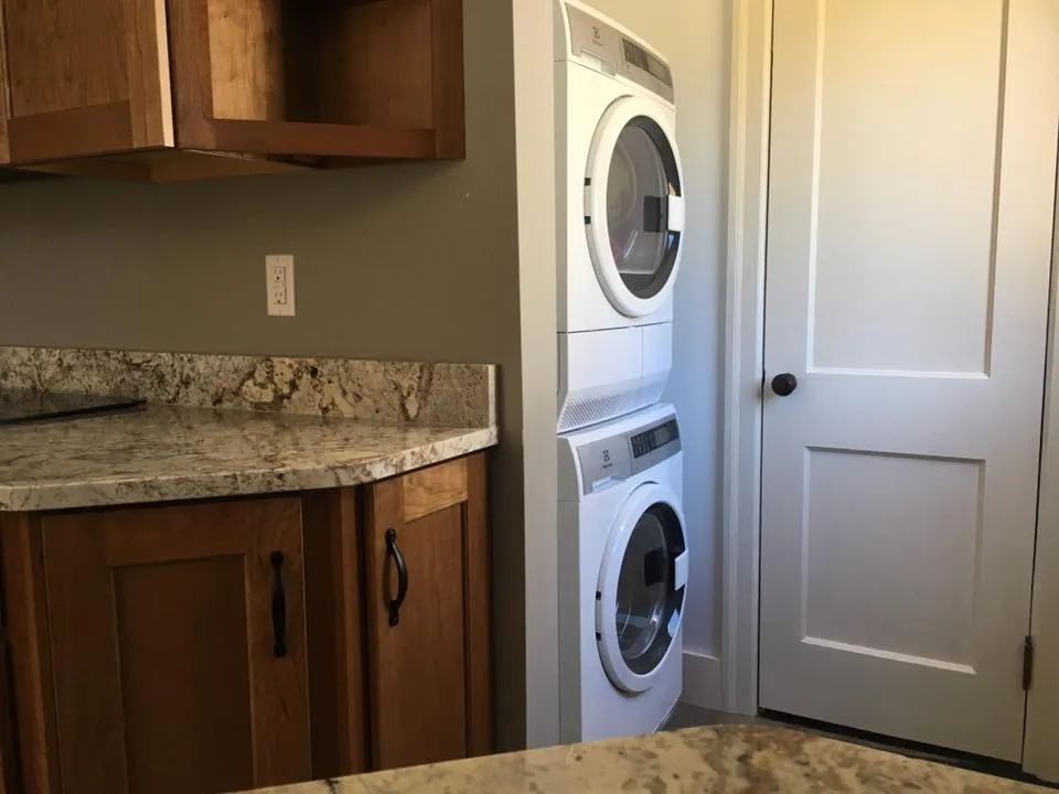 A laundry room with a washer and dryer stacked on top of each other.