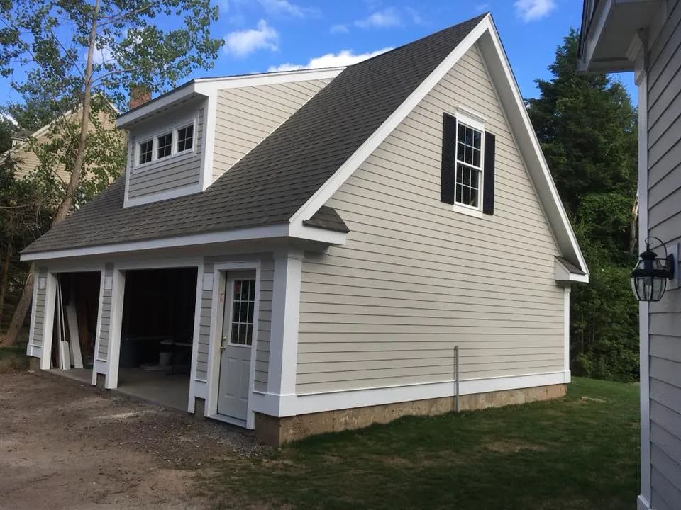 A white garage with a black roof and white trim