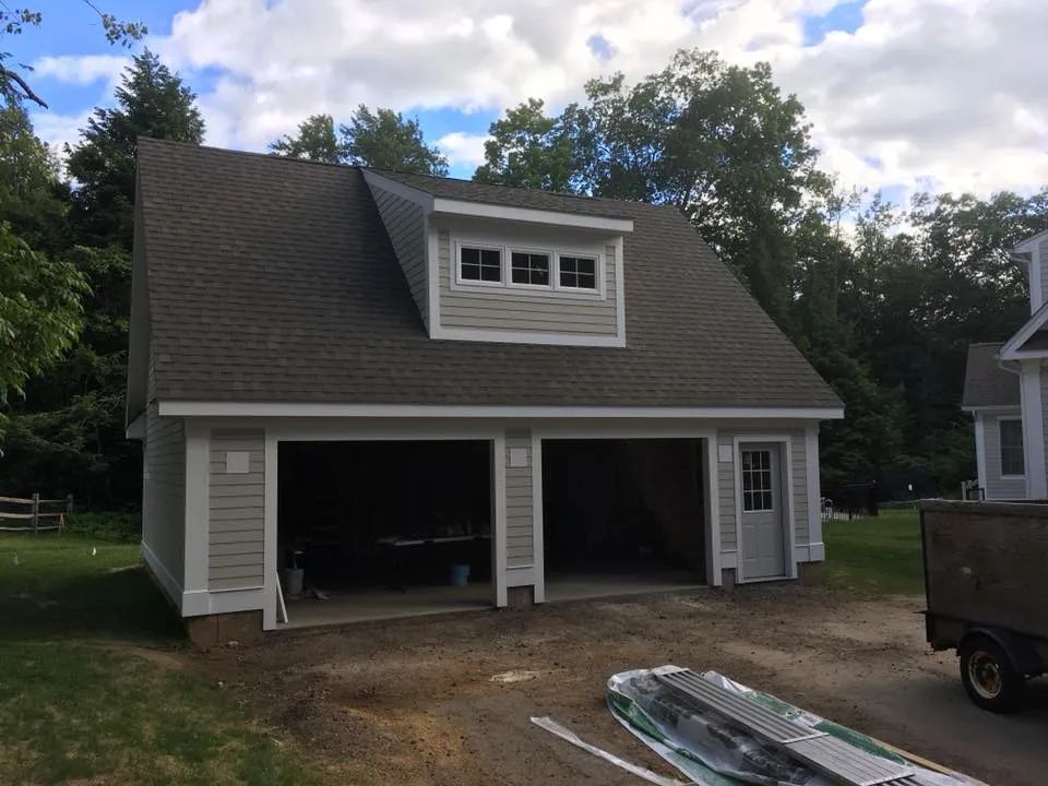 A garage with a gray roof and white trim