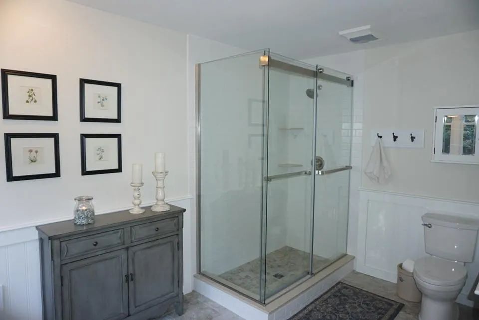 A bathroom with a toilet and a walk in shower.