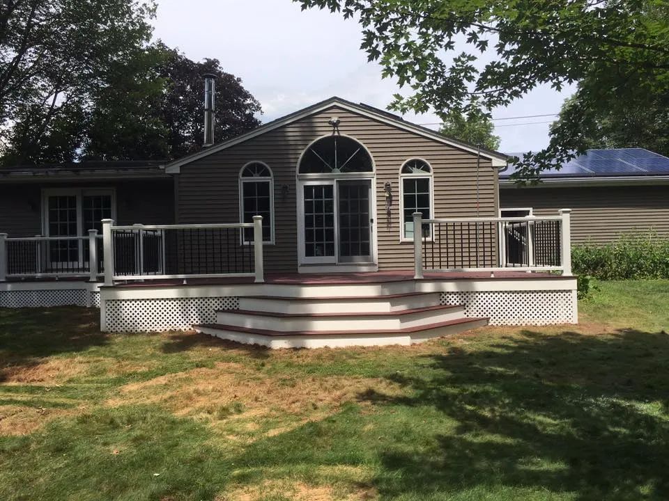 A house with a large deck in front of it