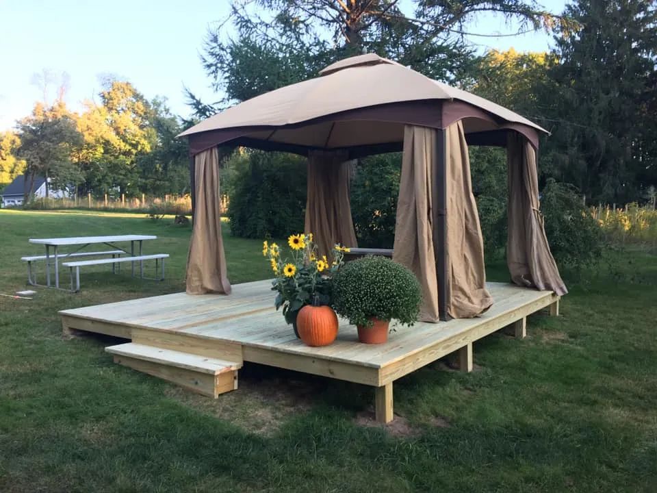 A gazebo with a canopy is sitting on top of a wooden deck.