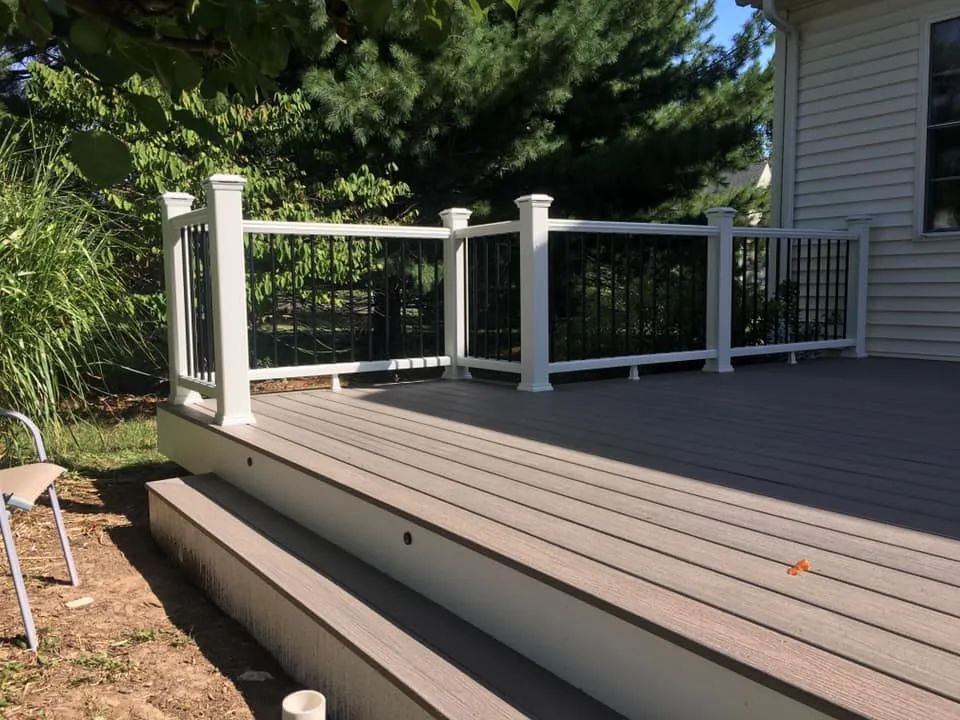 A wooden deck with a white railing and stairs