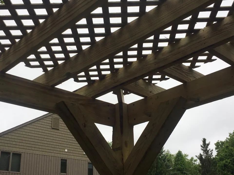 A wooden pergola is being built in front of a house