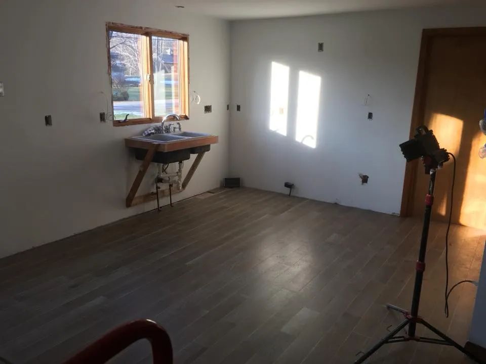 An empty room with a sink and two windows