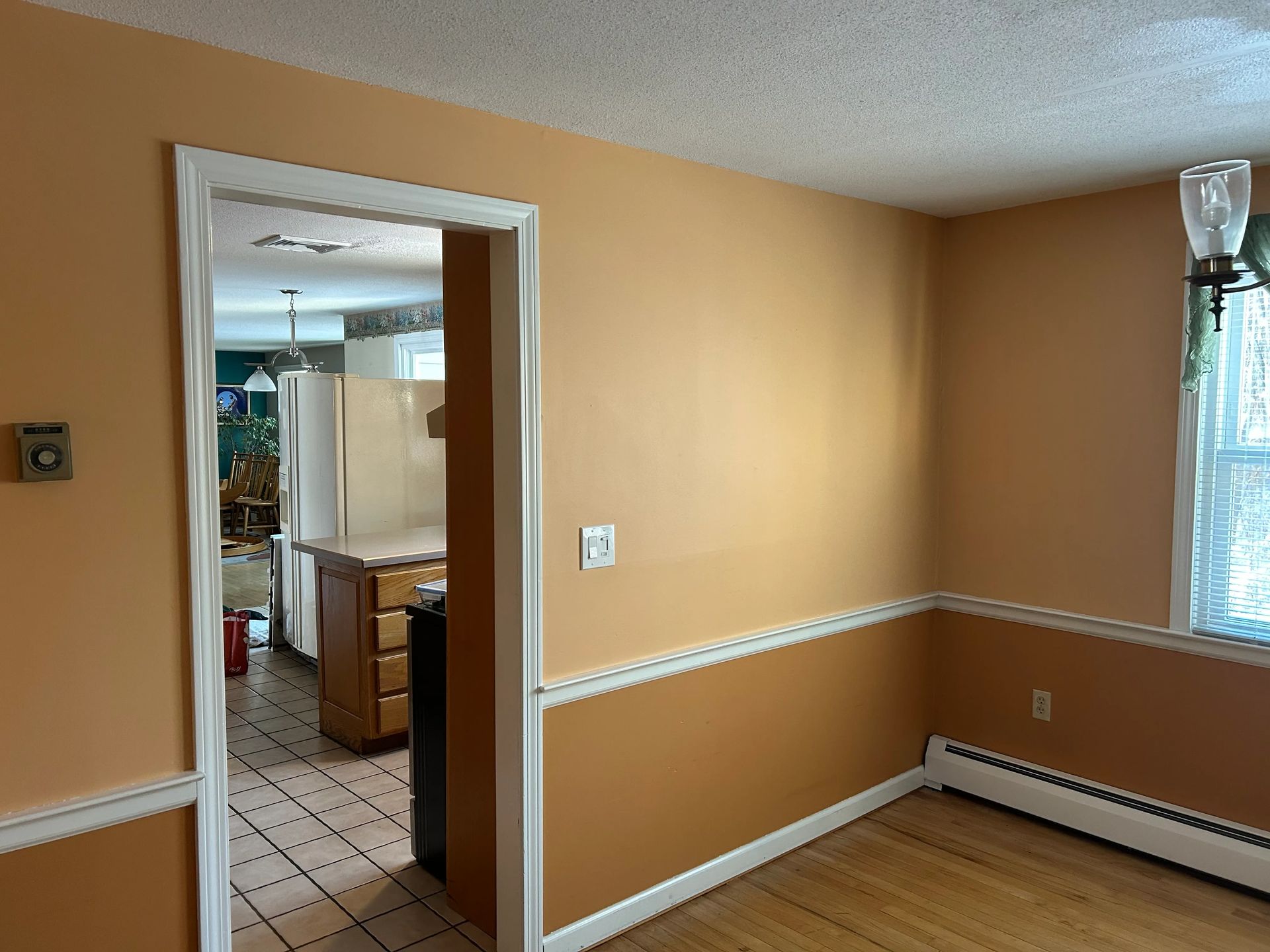 An empty room with orange walls and wooden floors