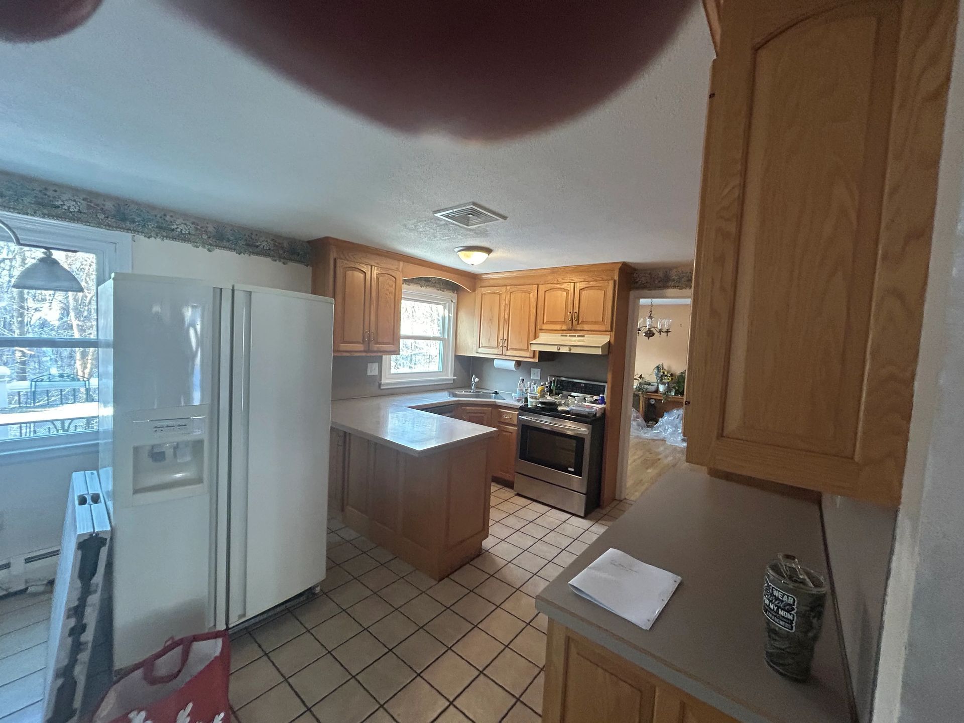 A kitchen with a refrigerator , stove , sink and cabinets.